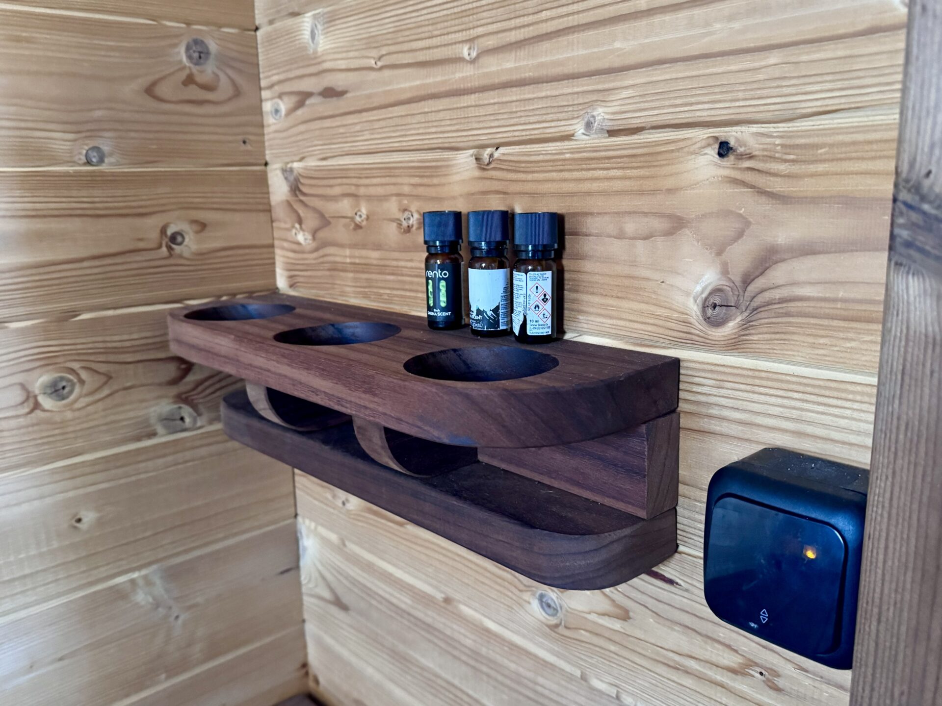 Holzregal mit runden Öffnungen zum Abstellen von Saunautensilien